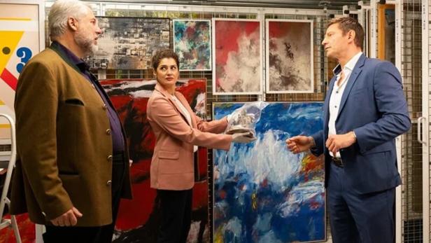 Frau zeigt in Galerie auf Bilder