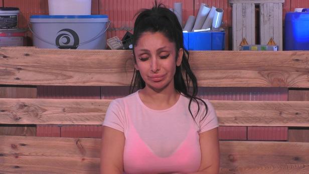 Frau sitzt mit geschlossenen Augen im Rohbau des TV-Containers