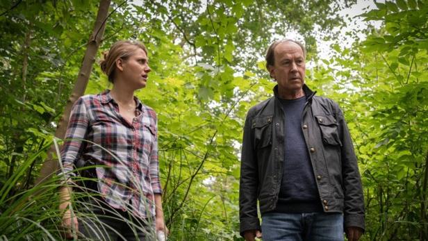 Ein Mann und eine Frau stehen im Wald