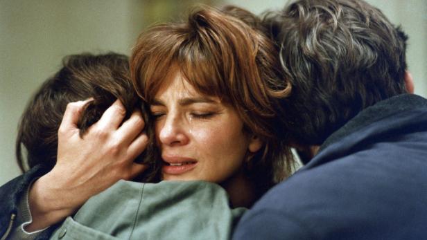 Weinende Frau umarmt einen Jungen