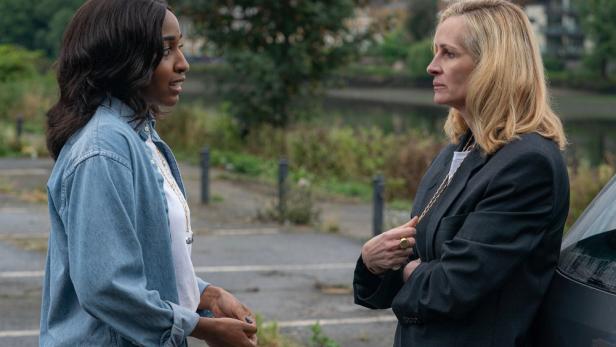 Zwei Frauen stehen einander auf einem Parkplatz gegenüber