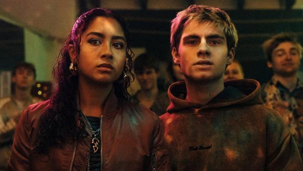 Junger Mann und junge Frau stehen nebeneinander auf einer Party