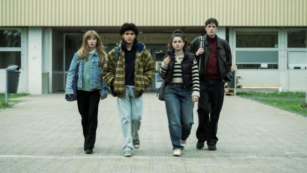 Vier Jugendliche gehen von einer Schule weg