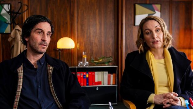 Mann und Frau sitzen in einem Anwaltsbüro nebeneinander