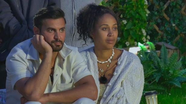 Mann und Frau sitzen nebeneinander im Garten