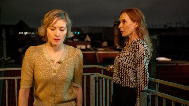 Zwei Frauen stehen nachts auf einem Balkon