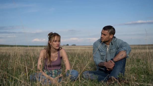 Mann und Frau sitzen nebeneinander in einem Feld