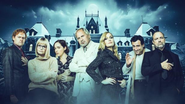 Sieben Personen vor düsterer Schloss-Kulisse