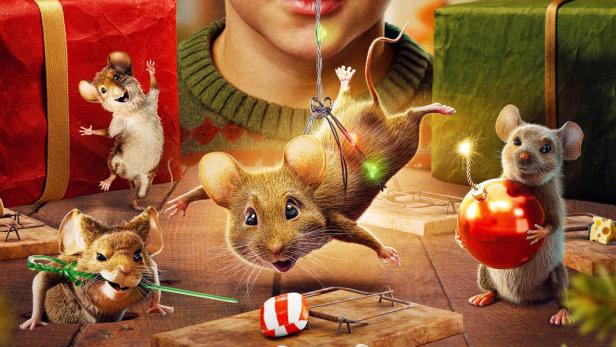 Junge beobachtet Mäuse, die mit weihnachtlichen Dingen spielen