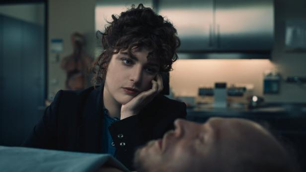 Frau betrachtet einen offenbar tote Mann in der Pathologie