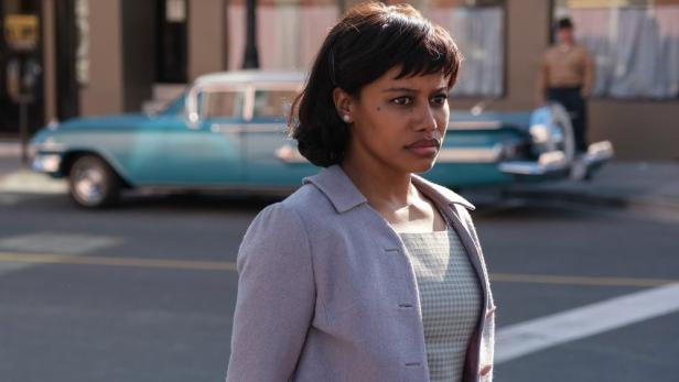 Frau steht auf Straße im Stil der 60er Jahre