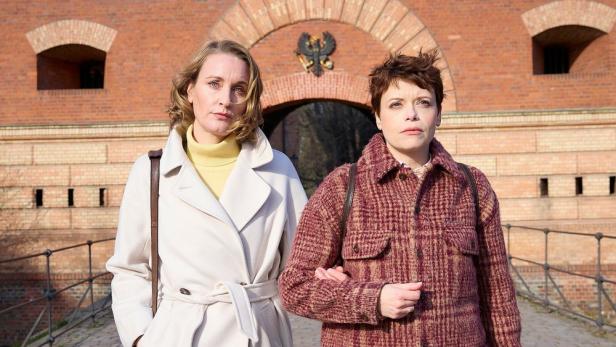 Zwei Frauen gehen ineinander eingehenkt vor der Zitadelle Spandau