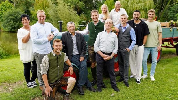 Gruppenbild von Bauern und Bäuerinnen vor Traktor