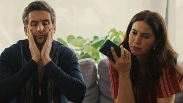 Tom Beck und Chryssanthi Kavazi sitzen in ihren Serienrollen nebeneinander auf einer Couch