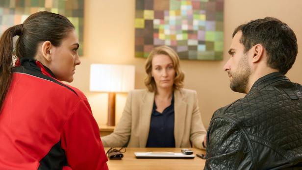 Mann und Frau sitzen vor Schreibtisch einer Anwältin