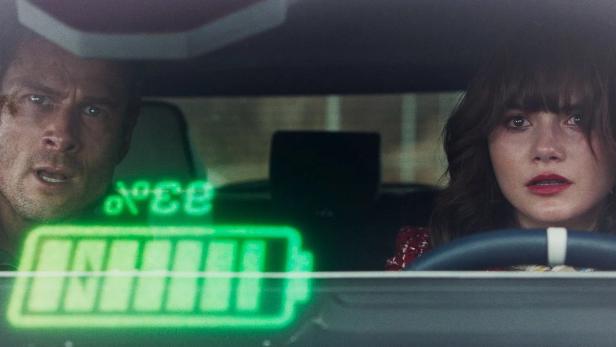 Mann und Frau fahren in Wagen und im Vordergrund erscheint eine Energie-Anzeige