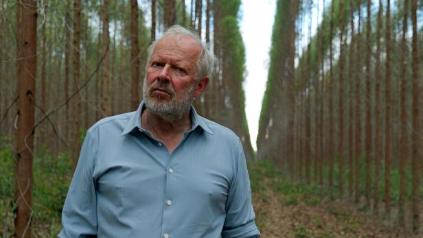 Axel Milberg vor langen Baumreihen