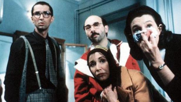 Mann in Weinhachtsmannmantel und drei weitere Personen blicken fassungslos auf etwas, das wir nicht sehen können