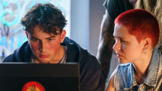 Junger Mann und junge Frau blicken auf ein Laptopscreen