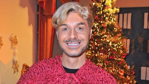 Sam Dylan vor geschmücktem Weihnachtsbaum