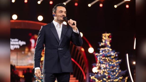 Giovanni Zarrella mit Mikro vor Christbaum im TV-Studio