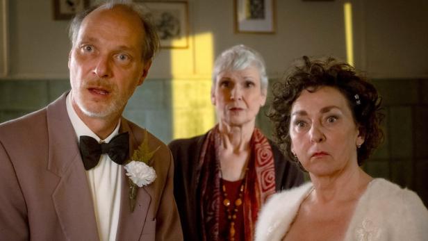 Zwei Frauen und ein Mann machen überraschte Gesichter