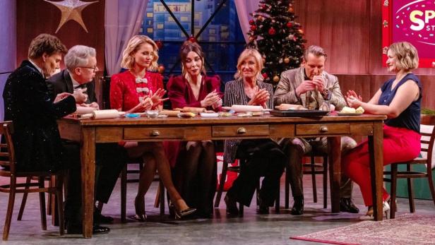 "Die Löwen"-Crew sitzt an einem weihnachtlichen Tisch im Studio