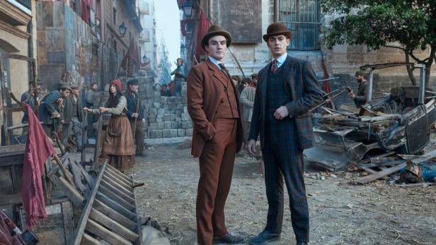 Hero Fiennes Tiffin steht als junger Sherlock Holmes auf einem Platz voller Bauschutt