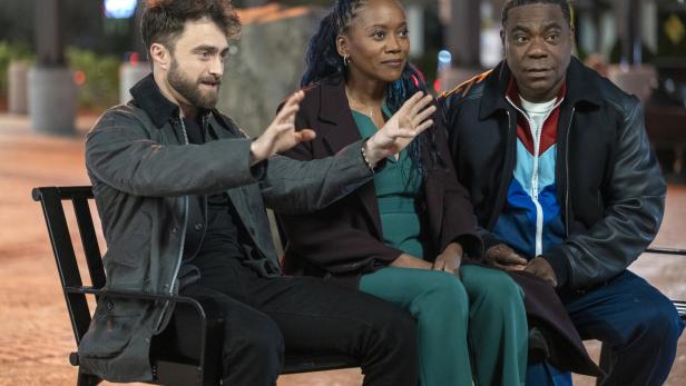 Daniel Radcliffe und Tracy Morgan sitzen in Serienrolle mir Frau auf einer Bank