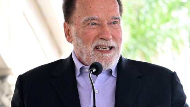 Arnold Schwarzenegger  bei einem Vortrag vor dem Mikro 