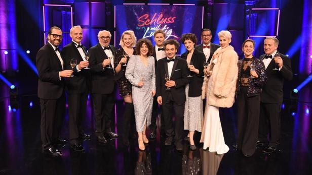 Diverse Moderatoren und TV-Größen mit Sektgläsern im Studio