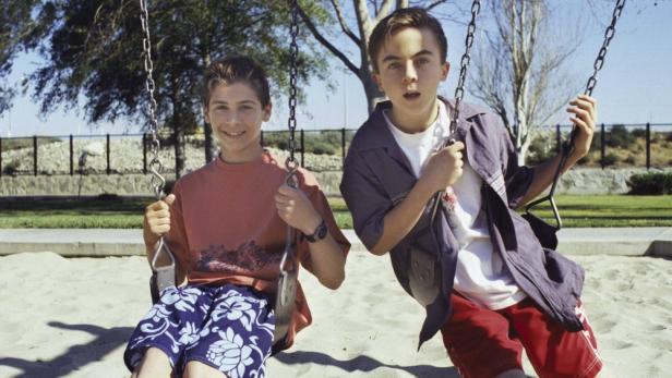 Justin Berfield und Frankie Muniz auf Schaukeln am Spielplatz in ihren Serienrollen