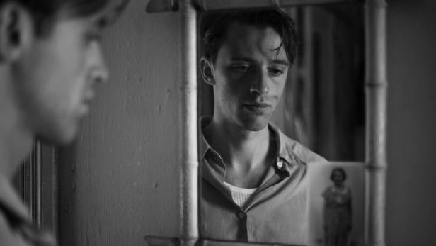 Benjamin Voisin blickt in seiner Rolle als Meursault in den Spiegel