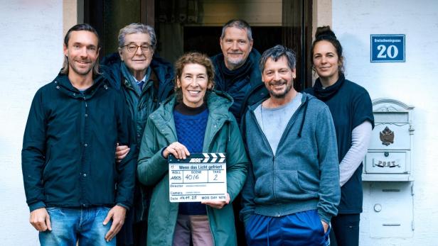 Gruppenbild des Film-Teams: Adele Neuhauser hält Filmklappe
