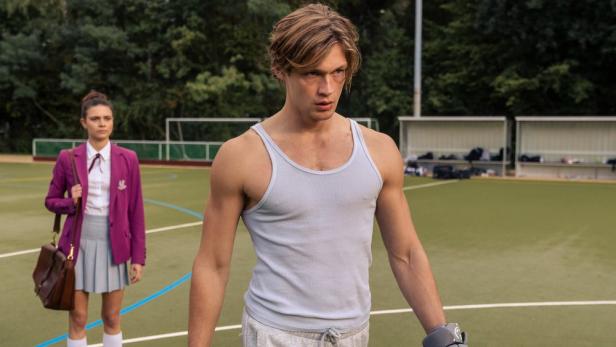 Zwei Hautpfiguren der Serie Maxton Hall auf einem Sportplatz