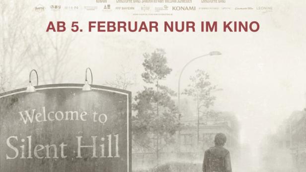 Menn steht auf Filmplakat neben Ortstafel zu Silent Hill