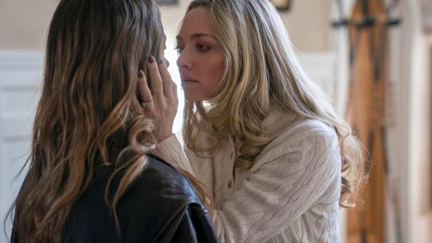 Amanda Seyfried fasst einer Frau vor ihr mit der Hand an ie Wange und nähert ihr Gesicht bedrohlich