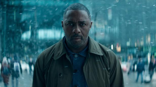 Idris Elba steht auf Straße in Schneetreiben
