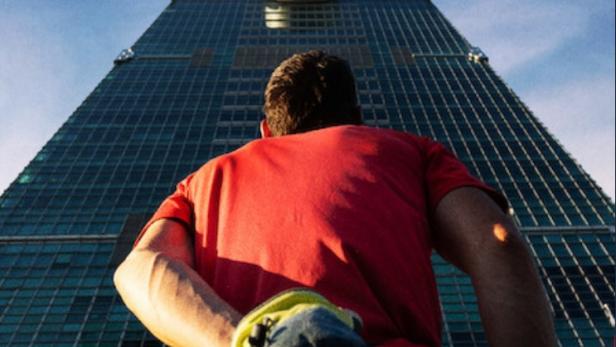 Kletterer Alex Honnold steht vor dem Wolkenkratzer Taipei 101
