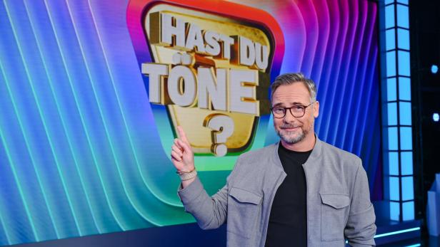 Matthias Opdenhövel zeigt im Studio auf den Schriftzug der Sendung "Hast du Töne?"