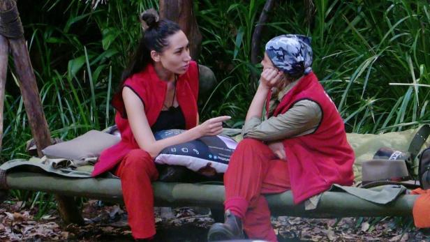 Eva Benetatou  und Samira Yavuz sitzen in ein Gespräch vertieft auf einem Dschungellager
