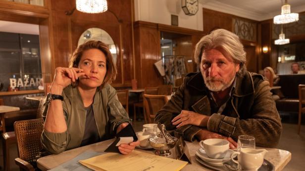 Mann und Frau sitzen an Kaffeehaustisch