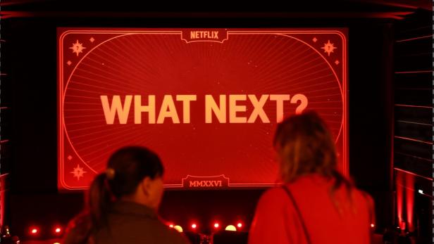 Zwei Zuschauerinnen vor dem Schriftzug "What Next"