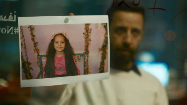 Mann hält ein Foto des Mädchens Hind Rajab in die Kamera