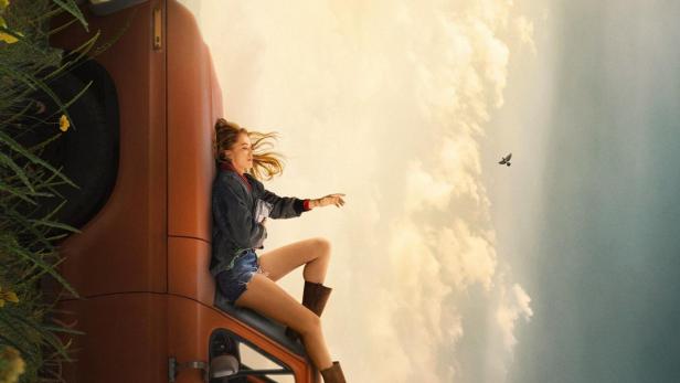 Frau liegt auf Autodach