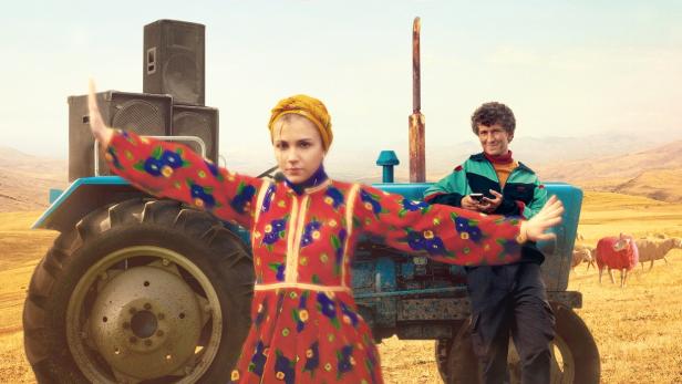 Frau in mazedonischer Tracht steht mit ausgebreiteten Armen vor einem Traktir