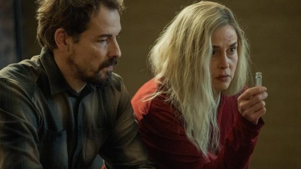 Ein Mann und eine Frau betrachten eine Phiole