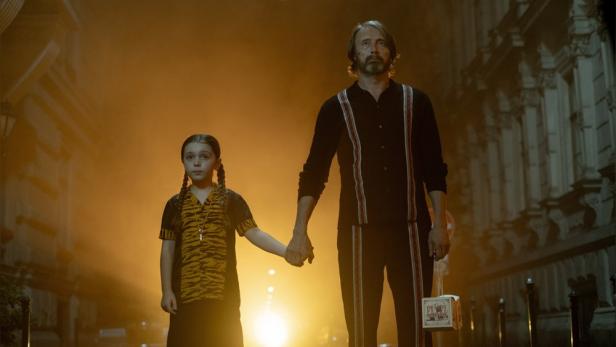 Mads Mikkelsen und die junge Neuentdeckung Sophie Sloan halten einander an den Händen