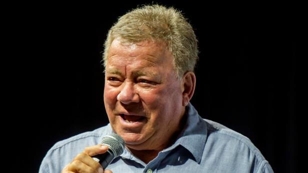 William Shatner mit einem Mikro in der Hand