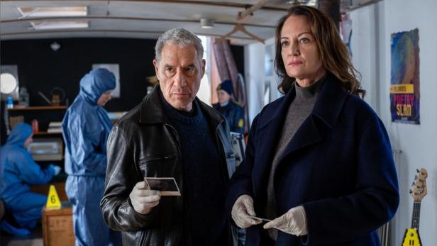 Zwei Ermittler durchsuchen ein Hausboot